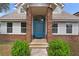 Close-up of the blue front door with brick accents and manicured landscaping at 1901 Lakeshore Cir, Longwood, FL 32750
