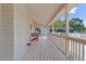 Relaxing front porch with wood floors, a red chair, and serene neighborhood views at 1901 Lakeshore Cir, Longwood, FL 32750