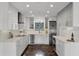 Modern white kitchen featuring stainless steel appliances, marble countertops, and unique flooring at 1901 Lakeshore Cir, Longwood, FL 32750