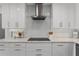 Close-up of a modern kitchen featuring stainless steel hood and cooktop, and light countertops at 1901 Lakeshore Cir, Longwood, FL 32750