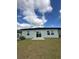 Rear exterior with sliding glass door and a small patio at 2082 Gold Dust Dr, Clermont, FL 34715
