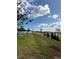 Backyard view showcasing land under a bright, cloudy sky at 2082 Gold Dust Dr, Clermont, FL 34715