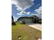 View of the home and long driveway from an angle on the lawn at 2082 Gold Dust Dr, Clermont, FL 34715