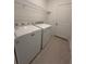 Laundry room with washer, dryer, wire rack and neutral tile flooring at 2082 Gold Dust Dr, Clermont, FL 34715