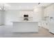 Modern kitchen features white cabinets, stainless steel appliances, and a large center island with sink at 2170 Derwent Dr, Davenport, FL 33896