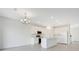 Open-concept kitchen features white cabinetry, stainless steel appliances, tile floors, and modern chandelier at 2170 Derwent Dr, Davenport, FL 33896