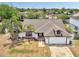 Aerial view of a single-story home showcasing its roofline, landscaping, and proximity to neighborhood trees at 2317 Clearwater Dr, Deltona, FL 32738