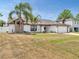 Inviting single-story home featuring a two-car garage and a lawn with mature trees and shrubs at 2317 Clearwater Dr, Deltona, FL 32738