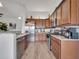 Modern kitchen with stainless steel appliances, wood cabinets, granite countertops, and wood-look flooring at 2317 Clearwater Dr, Deltona, FL 32738