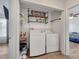 This laundry room includes a washer, dryer, and shelving for storage and convenience at 2317 Clearwater Dr, Deltona, FL 32738