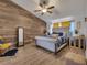 Inviting main bedroom featuring wood accent wall, neutral colors, ceiling fan, and lots of natural light at 2317 Clearwater Dr, Deltona, FL 32738