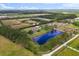Aerial view of property with home, outbuildings, pond and lush land at 240 Spring Forest Dr, New Smyrna Beach, FL 32168