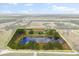 A sprawling country estate featuring a pond, residences, and framed by lush greenery and a yellow property line at 240 Spring Forest Dr, New Smyrna Beach, FL 32168