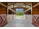 Interior view of barn with four stalls and a concrete floor at 240 Spring Forest Dr, New Smyrna Beach, FL 32168