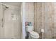 Charming bathroom featuring a stand-up shower, toilet, and modern decorative wallpaper at 240 Spring Forest Dr, New Smyrna Beach, FL 32168