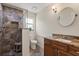 Modern bathroom with custom tiled shower, granite vanity and a round mirror at 240 Spring Forest Dr, New Smyrna Beach, FL 32168