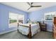 Inviting bedroom features blue walls, plush bedding and carpet, and natural light from windows at 240 Spring Forest Dr, New Smyrna Beach, FL 32168