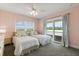 Charming bedroom with two beds, ceiling fan, and balcony access with treeline view at 240 Spring Forest Dr, New Smyrna Beach, FL 32168