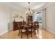 Elegant dining room with a chandelier, wooden furniture, large window with curtains, and hardwood floors at 240 Spring Forest Dr, New Smyrna Beach, FL 32168