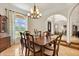 Formal dining room boasting a chandelier, wooden table with seating for six, and large windows at 240 Spring Forest Dr, New Smyrna Beach, FL 32168