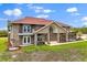 Two-story brick house with manicured lawn and a red tile roof, featuring lush landscaping and a covered entry at 240 Spring Forest Dr, New Smyrna Beach, FL 32168