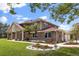 Brick exterior with manicured lawn and lush landscaping featuring tropical foliage and seasonal flower beds at 240 Spring Forest Dr, New Smyrna Beach, FL 32168