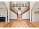 Grand foyer with split staircase, decorative wood floors, and arched alcoves that add architectural interest at 240 Spring Forest Dr, New Smyrna Beach, FL 32168