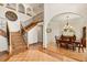 Elegant foyer featuring a wooden staircase with iron railings and an arched entryway into the dining room at 240 Spring Forest Dr, New Smyrna Beach, FL 32168