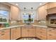 Bright kitchen featuring custom cabinets, granite countertops, undermount sink, and stone tile floors at 240 Spring Forest Dr, New Smyrna Beach, FL 32168