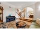 Open-concept living room with a piano, chess table, staircase, and an arched entrance to the dining room at 240 Spring Forest Dr, New Smyrna Beach, FL 32168