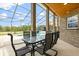 Covered patio features brick pillars, dining set, and screened pool views at 240 Spring Forest Dr, New Smyrna Beach, FL 32168