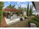 Relaxing backyard patio area with pergola, stylish furniture, and lush landscaping at 2602 Winter Park Rd, Winter Park, FL 32789