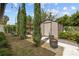 Landscaped backyard featuring a shed, trees, and decorative stone and paver accents at 2602 Winter Park Rd, Winter Park, FL 32789