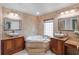 Bathroom featuring dual sinks, granite countertops, tile walls, and a garden tub at 2602 Winter Park Rd, Winter Park, FL 32789