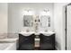 Beautiful bathroom features double sinks with dark cabinetry and stylish mirrors at 2611 Burwood Ave, Orlando, FL 32837