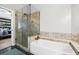 Modern bathroom featuring a glass shower, soaking tub, and decorative tile at 2611 Burwood Ave, Orlando, FL 32837