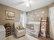 Neutral Bedroom with crib, recliner, and decorative flower decals on the wall at 2611 Burwood Ave, Orlando, FL 32837
