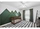 Bedroom features a crib, green accent wall and geometric patterned rug at 2611 Burwood Ave, Orlando, FL 32837