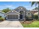 Charming single-story home featuring a gray facade, manicured lawn, and a two-car garage at 2611 Burwood Ave, Orlando, FL 32837