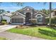 Beautiful gray single-story home featuring mature landscaping and a well-maintained lawn at 2611 Burwood Ave, Orlando, FL 32837