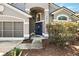 Close-up of the home's front door with an arched entryway, complemented by mature landscaping at 2611 Burwood Ave, Orlando, FL 32837