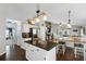 Bright, open-concept kitchen features a kitchen island, modern light fixtures, and flows into dining and living areas at 2611 Burwood Ave, Orlando, FL 32837