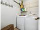 This laundry room features a washer and dryer, wire shelving, and a wall mounted coat rack at 2611 Burwood Ave, Orlando, FL 32837