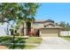 Well-maintained two-story home featuring a two-car garage, mature trees, and landscaped front yard at 2644 Slagrove Ct, Winter Garden, FL 34787