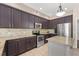This kitchen features dark cabinets, stainless steel appliances, and granite countertops with a center island at 2644 Slagrove Ct, Winter Garden, FL 34787
