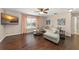 Open-concept living room with hardwood floors, large windows, neutral paint, and a comfortable couch at 2644 Slagrove Ct, Winter Garden, FL 34787