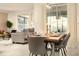 Open-concept dining area with a modern table set for six, adjacent to a living area with a view of the pool at 3009 Penelope Loop, Kissimmee, FL 34746