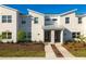 Modern townhome exterior with a clean white facade, symmetrical design, and minimalist landscaping on a sunny day at 3009 Penelope Loop, Kissimmee, FL 34746