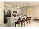 Stylish kitchen with gray cabinetry, a quartz countertop island with seating, and modern stainless-steel appliances at 3009 Penelope Loop, Kissimmee, FL 34746