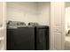 Bright laundry room featuring black washer and dryer, and a wire shelf at 3009 Penelope Loop, Kissimmee, FL 34746